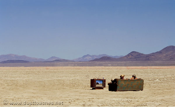 Couple of people watching television in plain desert