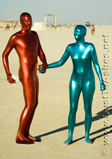 Burning man couple holding their hands on playa