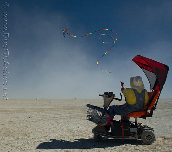 Man on wheelchair flying kite