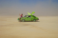 Woman with water mister posing on the art car in desert