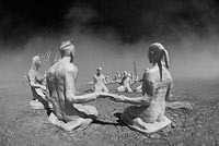 Plaster casts of people sitting in groups around the tipi