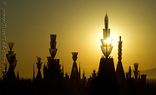 Burning Man Temple of Hope by Mark Grieve building outlines of wooden sculpture Silhouettes built by Sun rays in the background of the temple