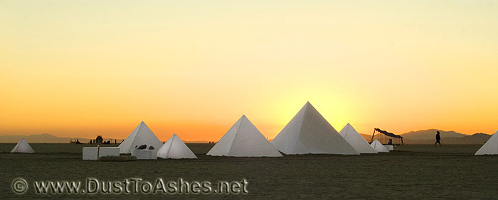 Silhouettes of white pyramids in desert picture